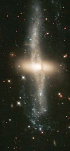 A disk of red stars ringed by dust, gas, and more stars.